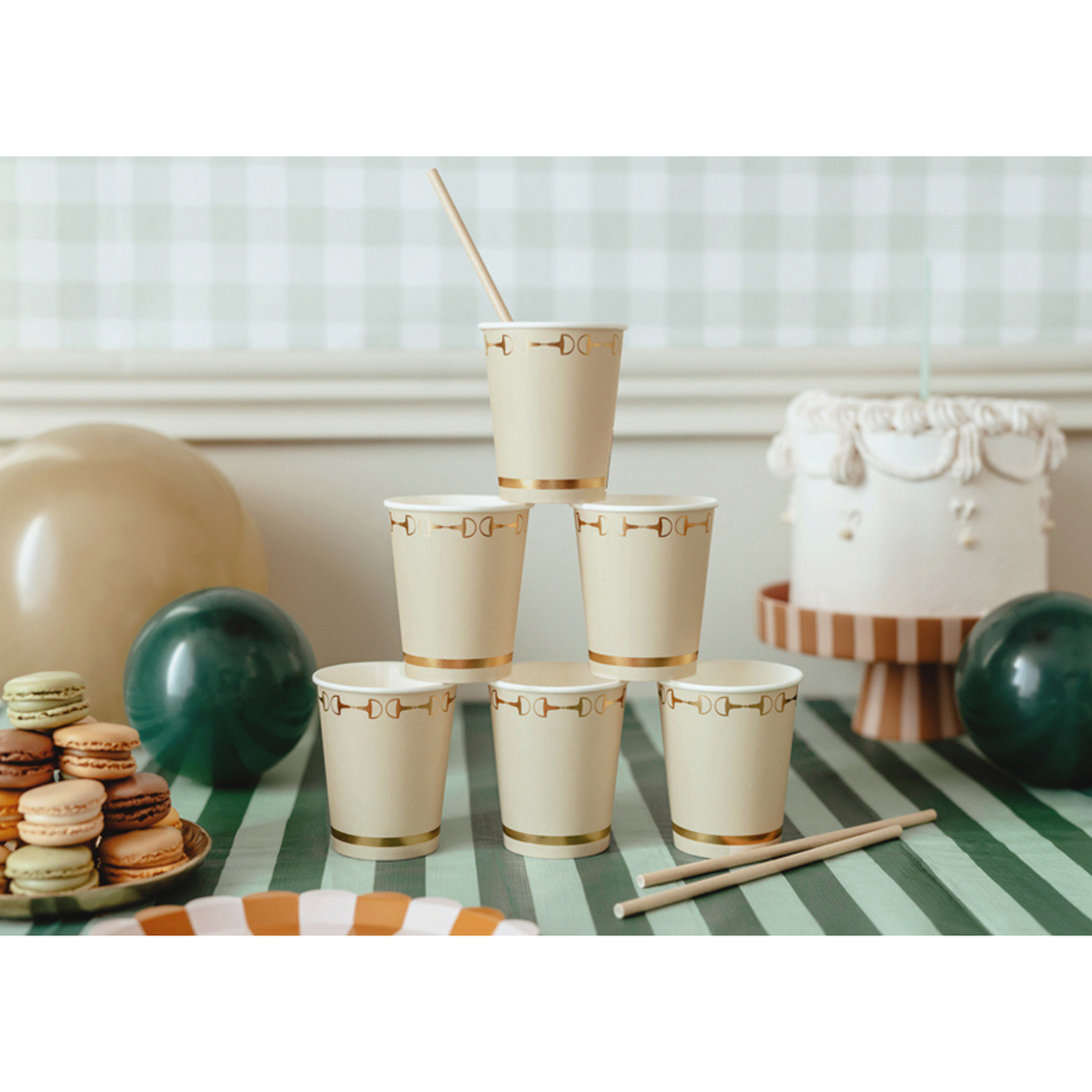 Feesttafel met papieren bekertjes in beige met gouden details, macarons en ballonnen