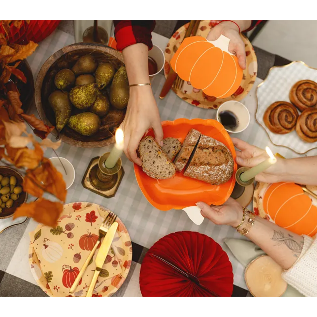 Oranje papieren pompoenbordje met brood op een sfeervol gedekte herfsttafel