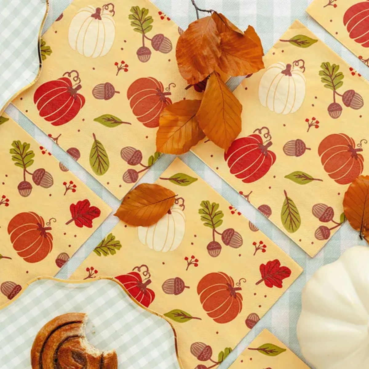 Servetten met pompoenen en eikels tussen herfstbladeren en herfstdecoratie