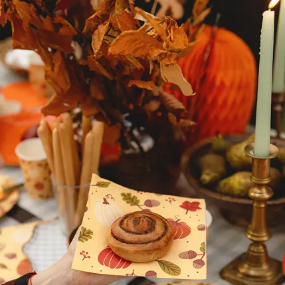 Servetten met pompoenen en eikels tussen herfstbladeren en herfstdecoratie